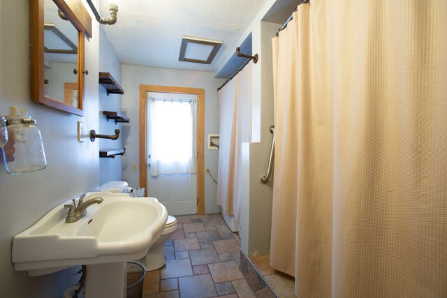 bathroom with walk in shower, a textured ceiling, and toilet