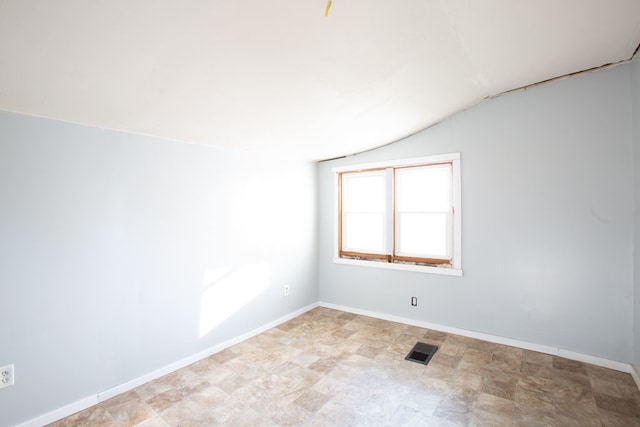 spare room with vaulted ceiling