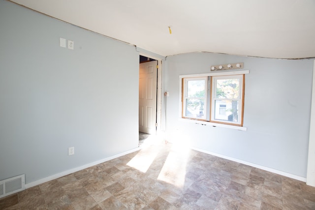 spare room featuring lofted ceiling