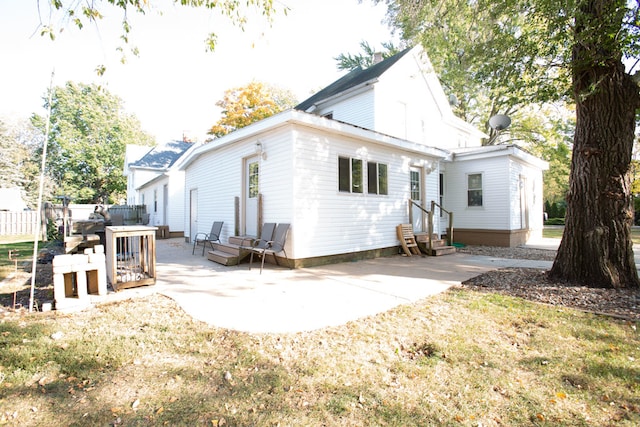 rear view of house featuring a patio and a lawn