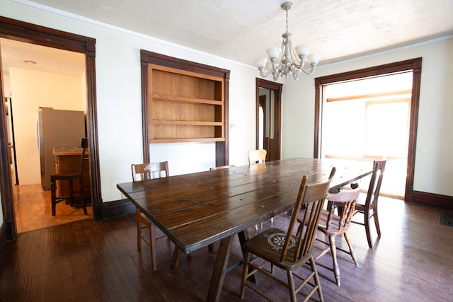 dining space with dark hardwood / wood-style floors, an inviting chandelier, and a textured ceiling