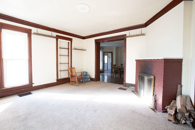 unfurnished living room with a brick fireplace, crown molding, and carpet floors