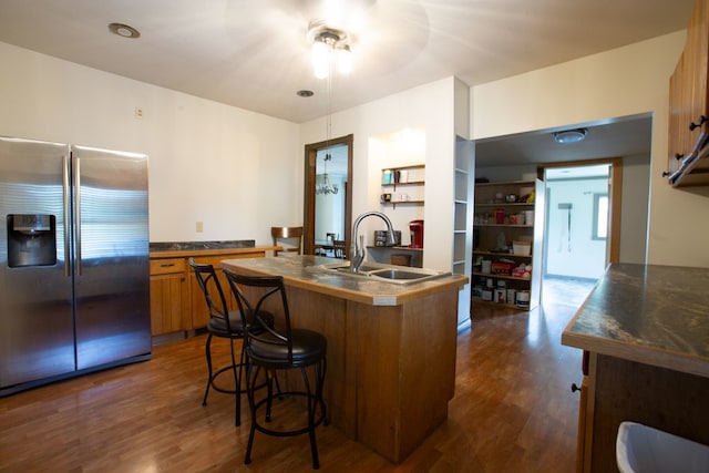 kitchen with an island with sink, stainless steel refrigerator with ice dispenser, dark hardwood / wood-style flooring, and sink