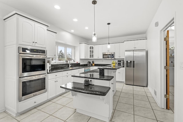 kitchen with white cabinetry, a center island, decorative light fixtures, and appliances with stainless steel finishes