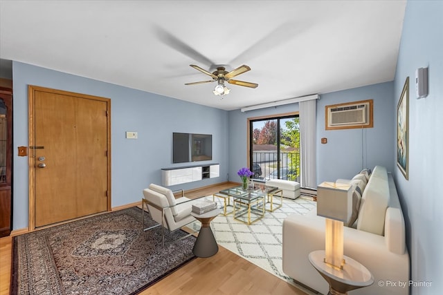 living room with ceiling fan, hardwood / wood-style flooring, and a wall unit AC