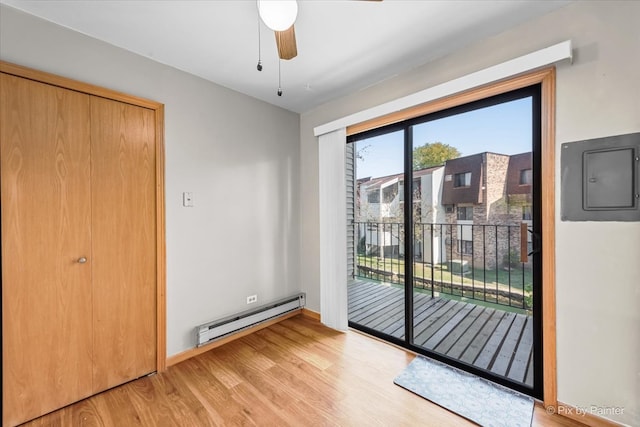 doorway with electric panel, ceiling fan, a baseboard radiator, and light hardwood / wood-style floors