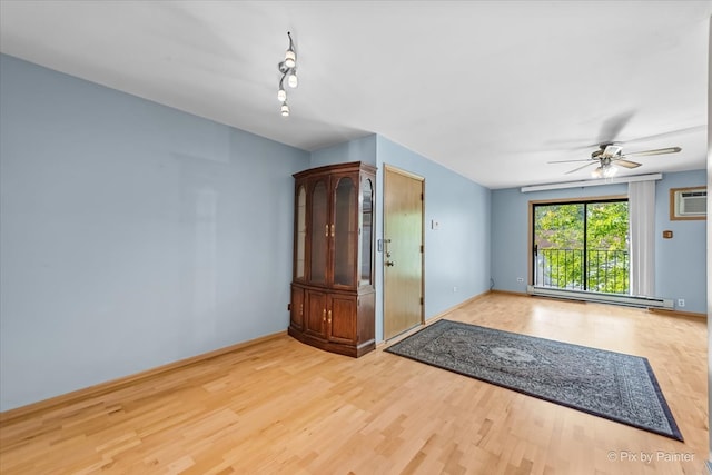 unfurnished room with an AC wall unit, baseboard heating, light wood-type flooring, and ceiling fan