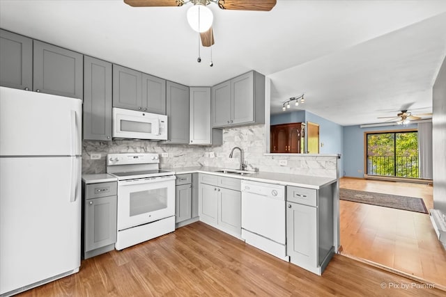 kitchen featuring sink, kitchen peninsula, white appliances, gray cabinets, and light hardwood / wood-style floors