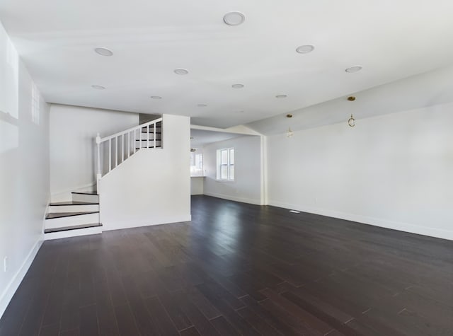 unfurnished living room featuring dark wood-type flooring