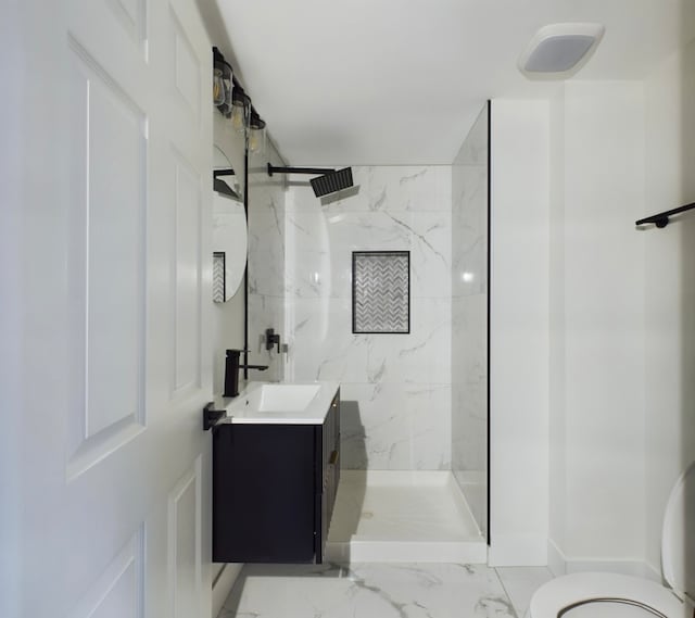 bathroom featuring vanity, toilet, and a tile shower