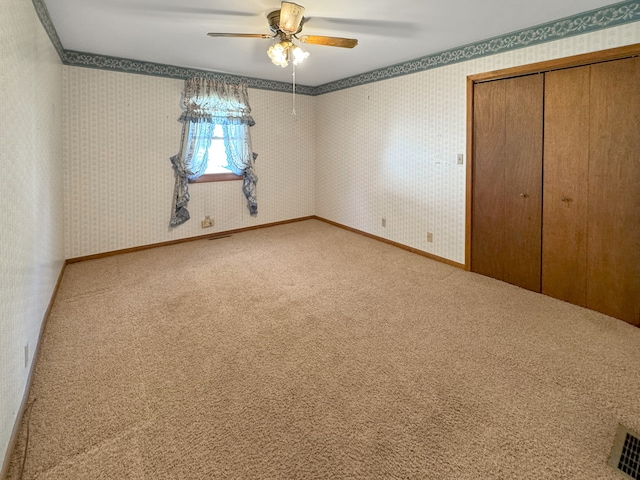 unfurnished bedroom with a closet, ceiling fan, ornamental molding, and carpet floors