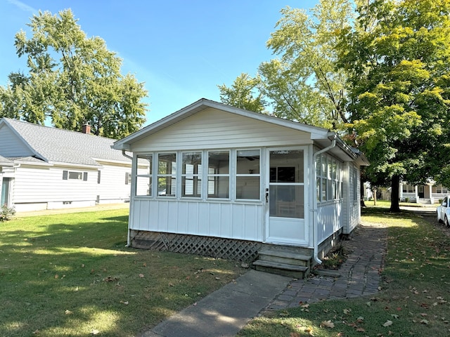 exterior space with a front lawn and a sunroom