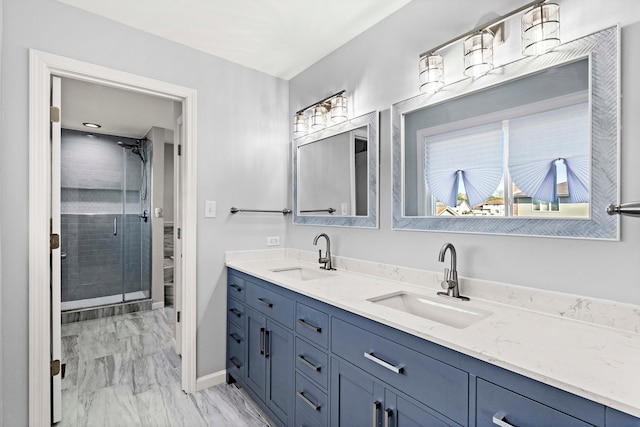 bathroom with a shower with shower door and vanity