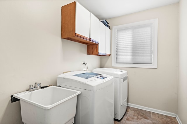 clothes washing area with light tile patterned flooring, cabinets, separate washer and dryer, and sink