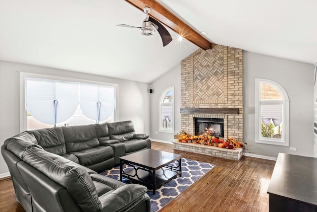 living room featuring a fireplace, dark hardwood / wood-style floors, vaulted ceiling with beams, and ceiling fan