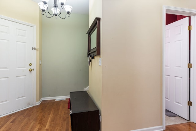 foyer entrance with a chandelier and dark wood-type flooring