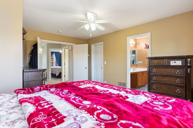 bedroom featuring ceiling fan, ensuite bath, and sink