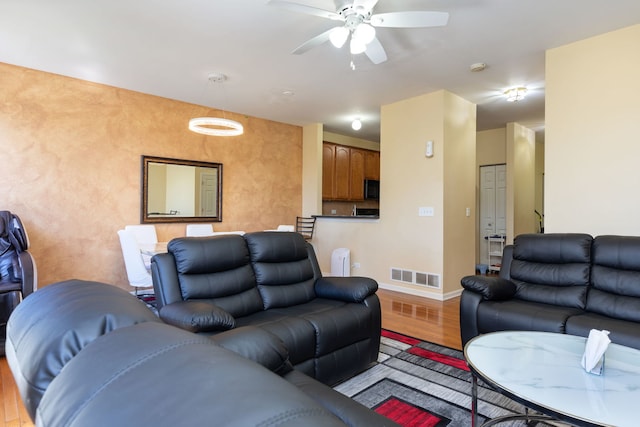 living room featuring ceiling fan and light hardwood / wood-style floors