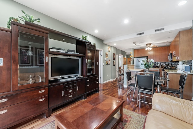 living room featuring ceiling fan and dark wood-type flooring