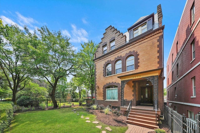 view of front facade with fence, a front lawn, and brick siding