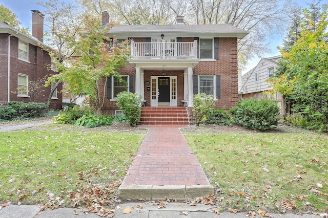 view of front of home with a balcony and a front lawn