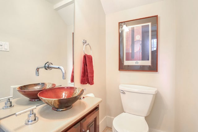 bathroom featuring vanity, toilet, and lofted ceiling