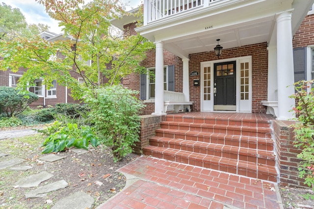 property entrance featuring a balcony and covered porch