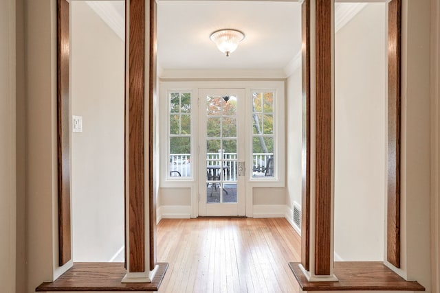 doorway to outside featuring light hardwood / wood-style floors and ornamental molding