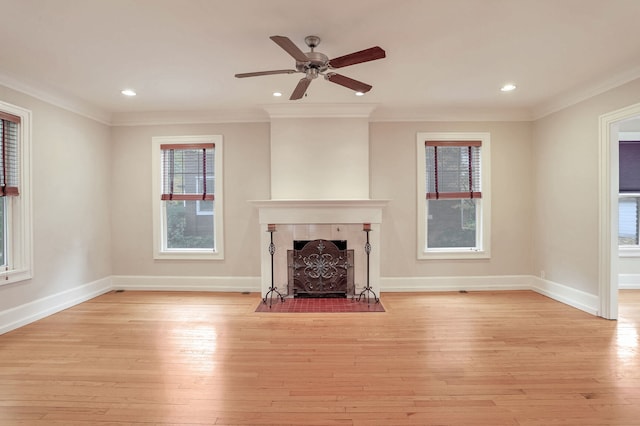 unfurnished living room with crown molding, light wood-type flooring, a fireplace, and ceiling fan