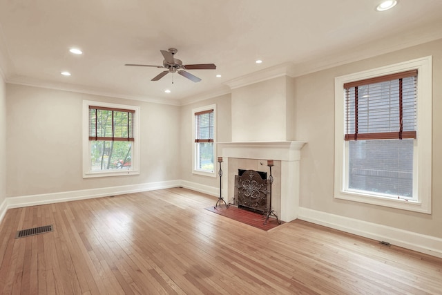 unfurnished living room featuring ceiling fan, ornamental molding, and light hardwood / wood-style flooring