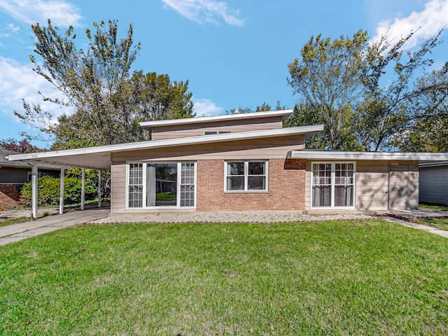 back of house featuring a lawn and a carport