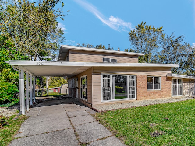 view of front of home with a front yard and a carport