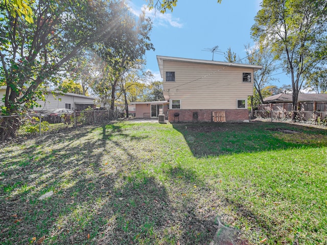 back of house with a yard and central AC unit