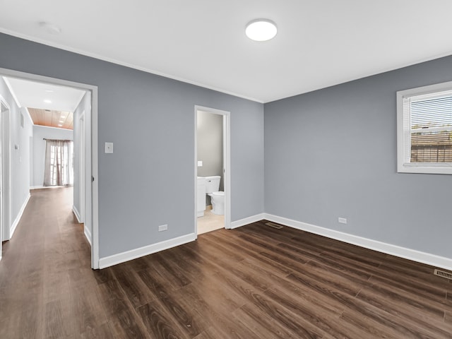 unfurnished bedroom with dark hardwood / wood-style floors and ensuite bath