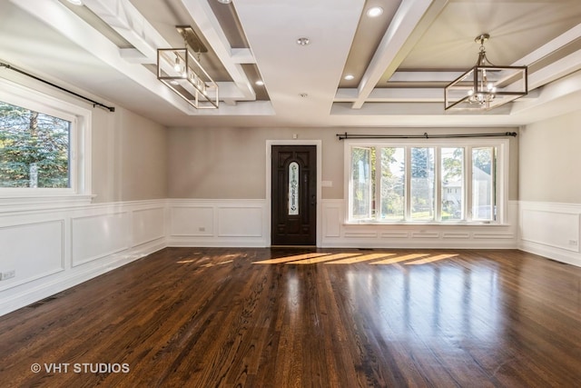 entrance foyer with a notable chandelier, dark wood-type flooring, plenty of natural light, and beam ceiling