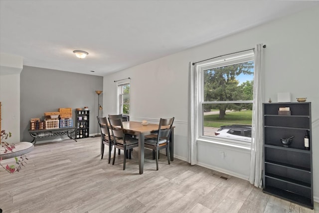 dining room featuring light wood-type flooring and a healthy amount of sunlight