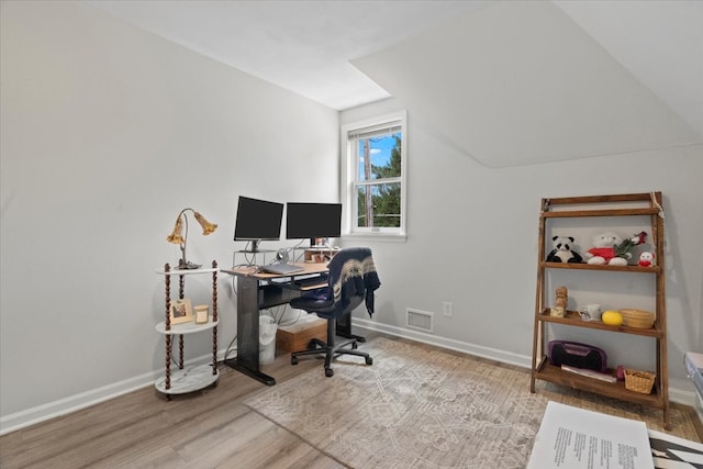 home office featuring vaulted ceiling and hardwood / wood-style flooring