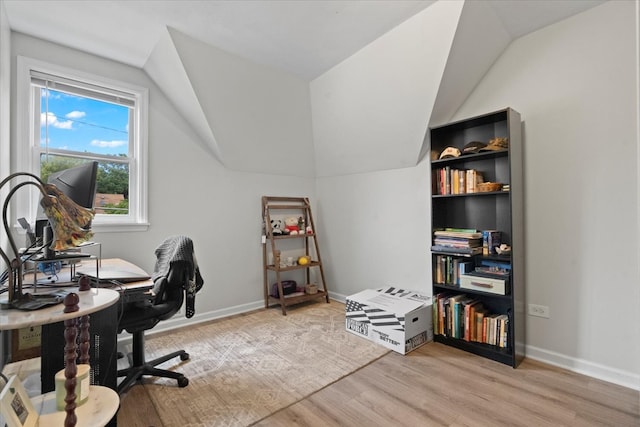 office with vaulted ceiling and light hardwood / wood-style flooring