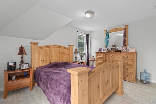 bedroom featuring light wood-type flooring and vaulted ceiling