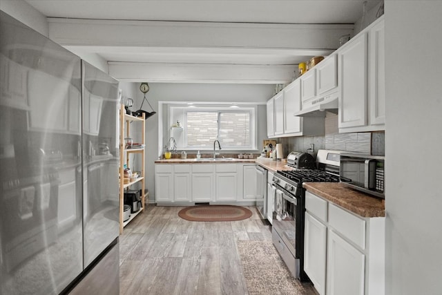 kitchen featuring decorative backsplash, light hardwood / wood-style flooring, sink, stainless steel appliances, and white cabinets