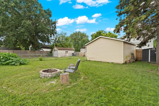 view of yard featuring a storage shed and a fire pit