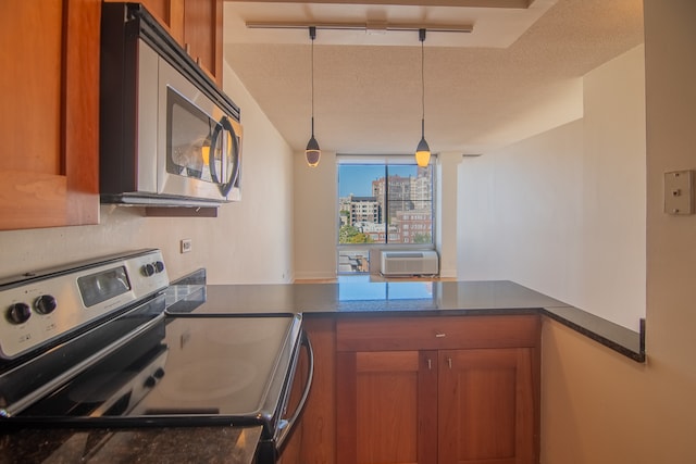 kitchen with a textured ceiling, kitchen peninsula, ornate columns, stainless steel appliances, and pendant lighting