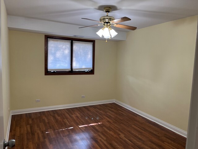 empty room with dark hardwood / wood-style flooring and ceiling fan