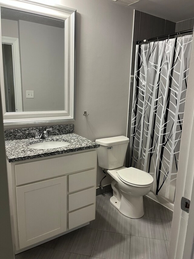 bathroom featuring tile patterned flooring, vanity, and toilet