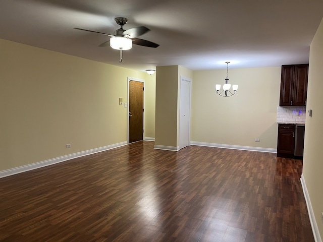 empty room featuring ceiling fan with notable chandelier and dark hardwood / wood-style floors