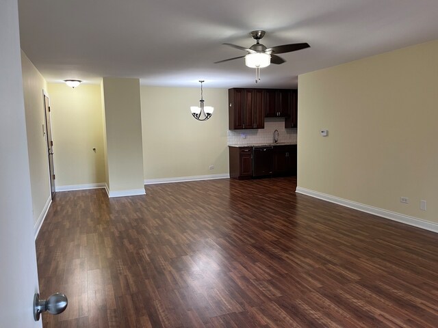 unfurnished living room with ceiling fan with notable chandelier, sink, and dark hardwood / wood-style floors