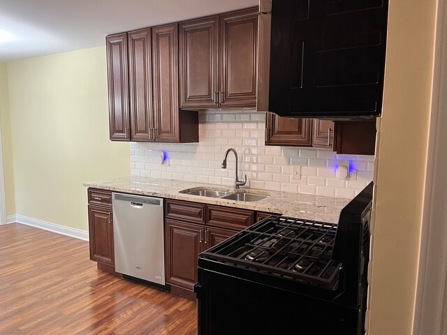 kitchen with dishwasher, tasteful backsplash, sink, and dark hardwood / wood-style flooring