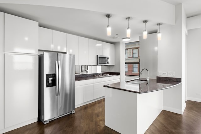 kitchen with pendant lighting, stainless steel appliances, dark wood-type flooring, and white cabinets