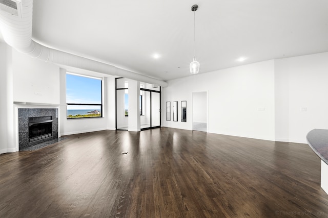 unfurnished living room featuring dark wood-type flooring and a fireplace