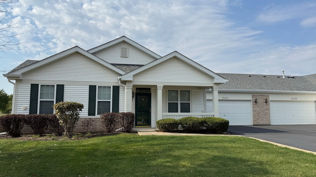 single story home featuring a front lawn and a garage